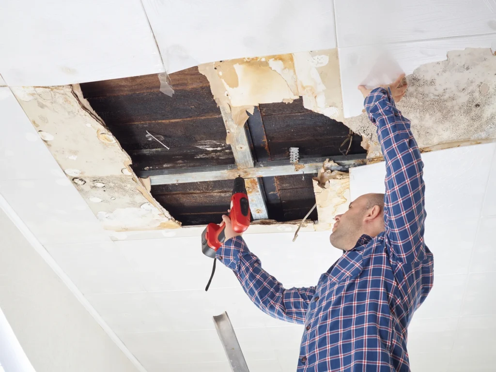man repairing water leaked ceiling