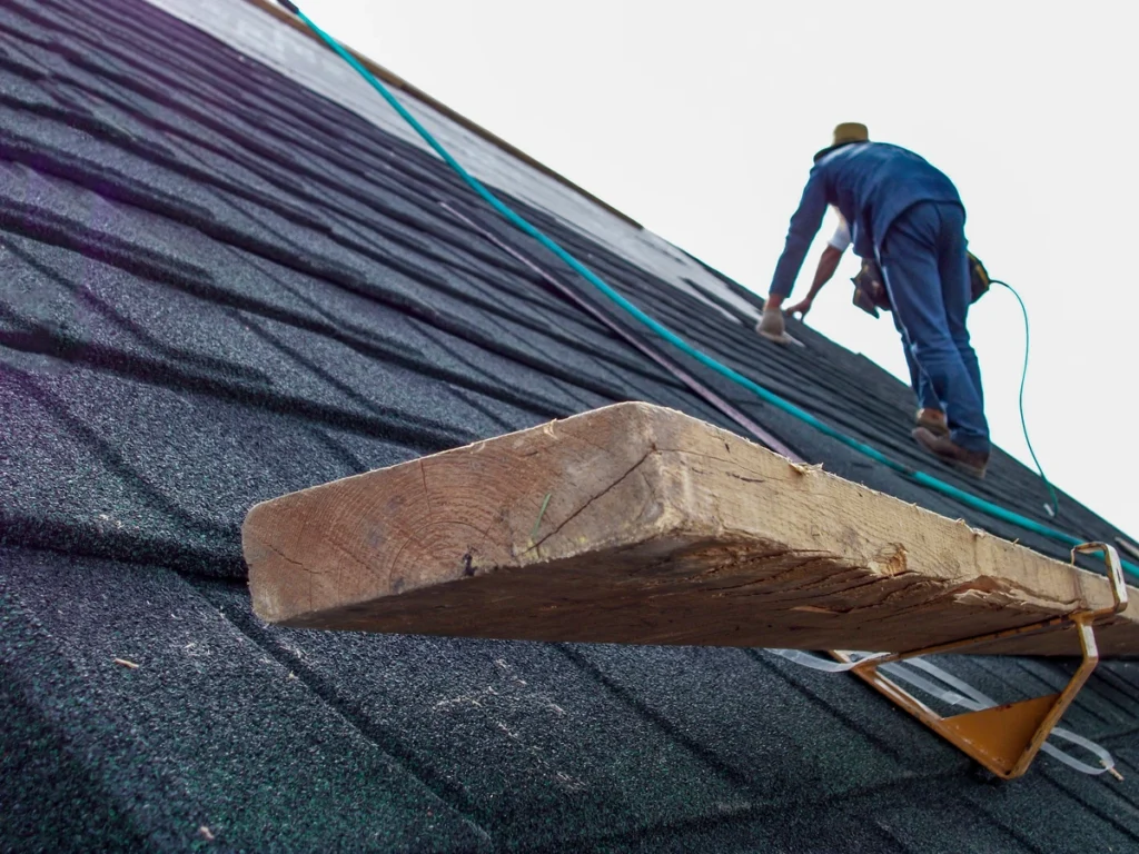 worker installing black shingles 1